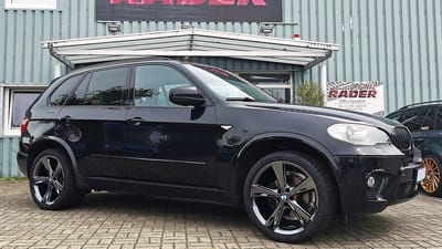 Schwarzer BMW X5 mit glänzend schwarzen Original-Felgen im 5-Speichen-Design