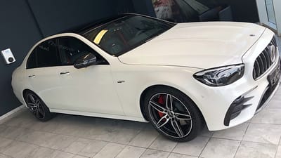 Weißer Mercedes-Benz E53 AMG mit roten Bremssätteln und glanzgedrehten Original-Felgen im 5-Doppelspeichen-Design