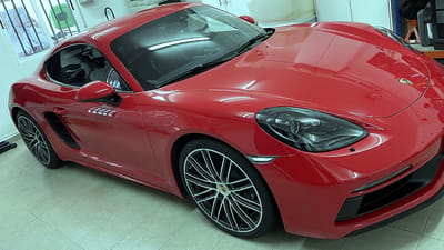 Roter Porsche Cayman mit roten Bremssätteln und glanzgedrehten schwarzen Original-Felgen