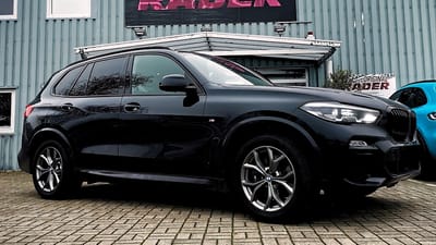 BMW X5 in Schwarz mit blauen Bremssätteln und grauen Original-Felgen im Doppelspeichen-Design