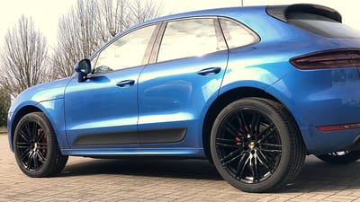 Porsche Macan GTS in Blau Metallic mit roten Bremssätteln und glänzend schwarzen Original-Felgen