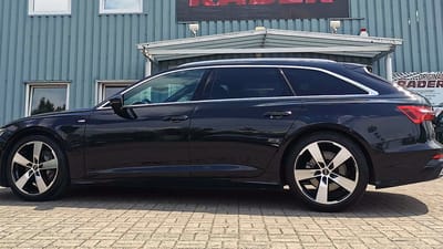 Schwarzer Audi A6 in der Seitenansicht, ab der B-Säule getönte Scheiben, dazu glanzgedrehte Original-Felgen im 5-Arm-Design