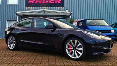 Tesla Model 3 Performance mit Original-Felgen Schwarzes Tesla Model 3 Performance mit roten Bremssätteln und silbernen Original-Felgen im Turbinen-Design