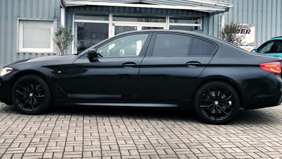 BMW 5er in Schwarz mit schwarzen Original-Felgen im Vielspeichen-Design