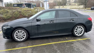 Mercedes-Benz A-Klasse auf Original-Felgen Mercedes-Benz A-Klasse in Schwarz auf nassem Asphalt, Seitenansicht mit silbernen Original-Felgen im 10-Speichen-Design