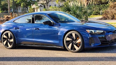 Audi e-tron GT auf Original-Felgen Blauer Audi e-tron GT mit orangefarbenen Bremssätteln und schwarz-silbernen Original-Felgen