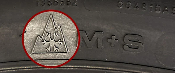 Alpine-Symbol auf Winterreifen: Bedeutung und Kennzeichnung für sicheren Winterverkehr Nahaufnahme eines Winterreifens mit dem Alpine-Symbol, das eine Schneeflocke in einem Bergdreieck zeigt, zur Kennzeichnung von Reifen für extreme Winterbedingungen