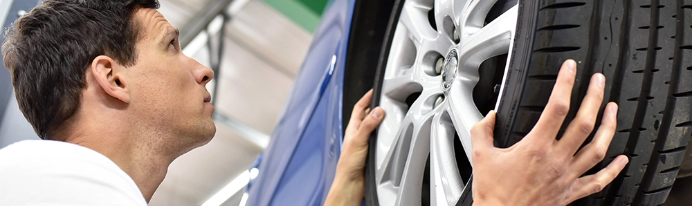 Reifenmontage in der Werkstatt – Schritt für Schritt sicher arbeiten Mechaniker bei der Reifenmontage an einem Auto – Nahaufnahme einer Aluminiumfelge