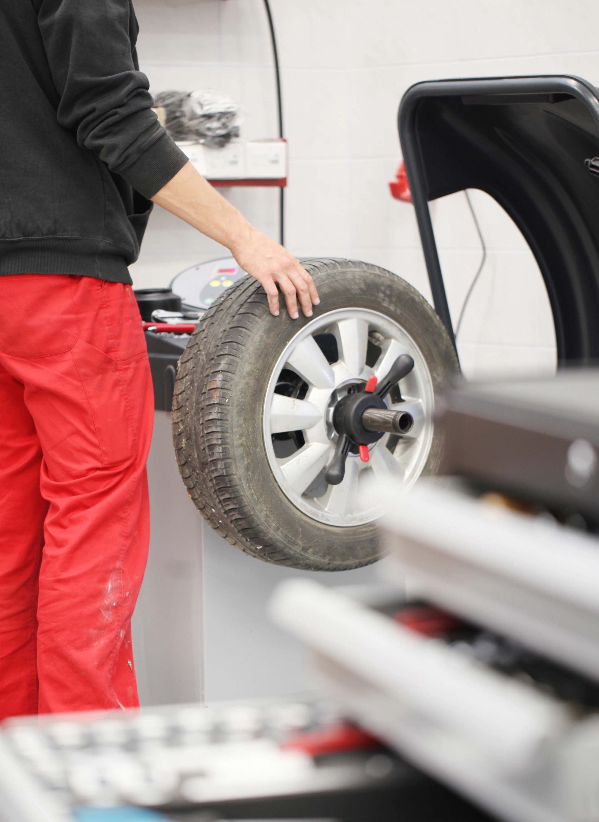 Rad auswuchten in der Werkstatt Mechaniker überprüft ein Rad während des Auswuchtens in der Werkstatt